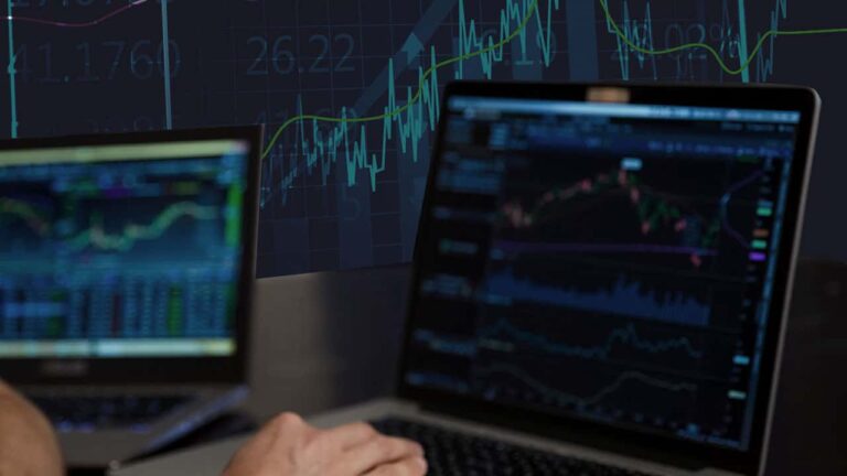 a trader in front of screens with trading charts